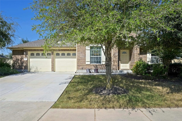 view of property hidden behind natural elements featuring a garage and a front lawn