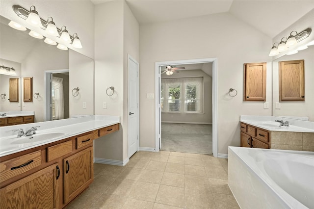 bathroom with lofted ceiling, a tub to relax in, tile patterned floors, ceiling fan, and vanity