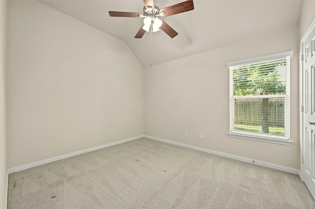 carpeted spare room with vaulted ceiling and ceiling fan