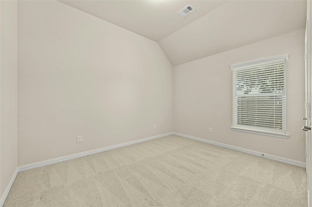 empty room with light carpet and vaulted ceiling