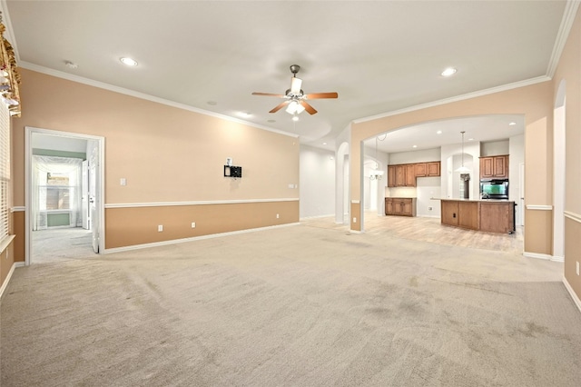 unfurnished living room with light carpet, ceiling fan, and crown molding