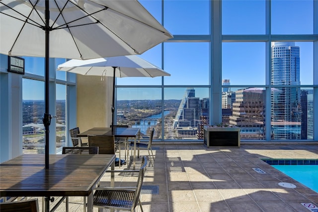 view of patio / terrace featuring a water view, a balcony, and a community pool