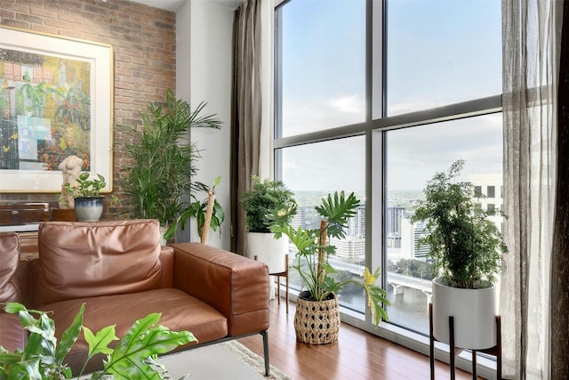 interior space with brick wall and hardwood / wood-style floors