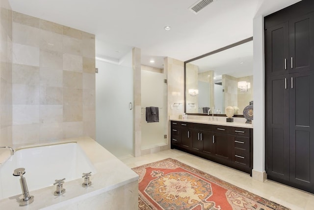 bathroom with tile patterned flooring, independent shower and bath, and vanity