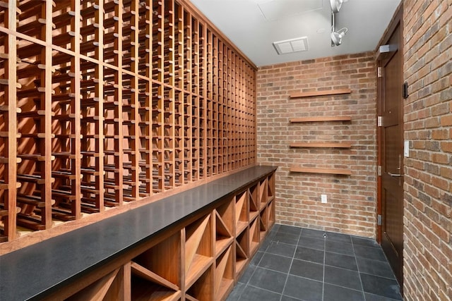 wine room featuring tile patterned flooring and brick wall