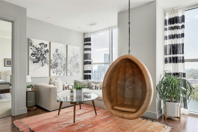 living area with a wall of windows and dark wood-type flooring