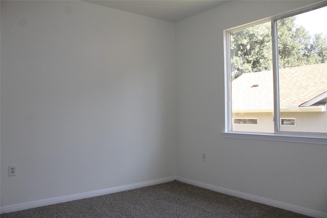 carpeted spare room with plenty of natural light and baseboards