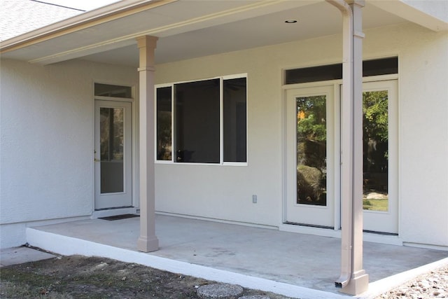 doorway to property featuring a patio area and stucco siding