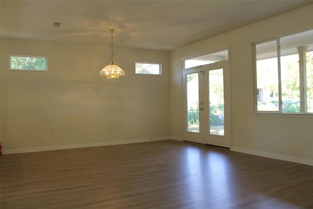 spare room featuring french doors, dark wood finished floors, visible vents, and baseboards