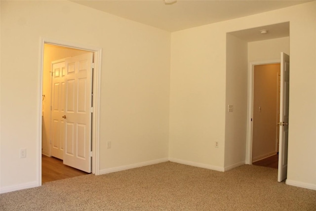 spare room featuring carpet flooring and baseboards