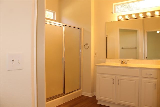 bathroom featuring a stall shower, vanity, and wood finished floors