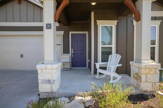 entrance to property with covered porch and a garage