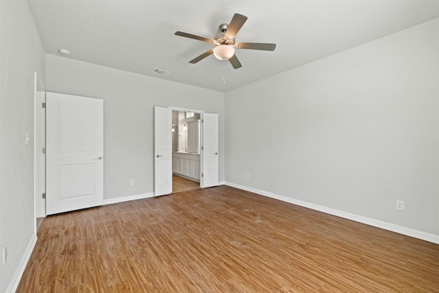 unfurnished bedroom with ceiling fan, light wood-type flooring, and ensuite bathroom