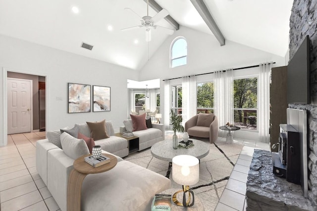 tiled living room featuring beam ceiling, high vaulted ceiling, a wood stove, and ceiling fan