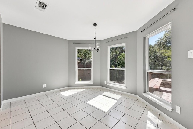 unfurnished dining area featuring light tile patterned flooring and an inviting chandelier