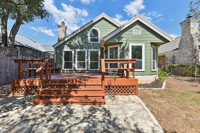 rear view of house featuring a wooden deck