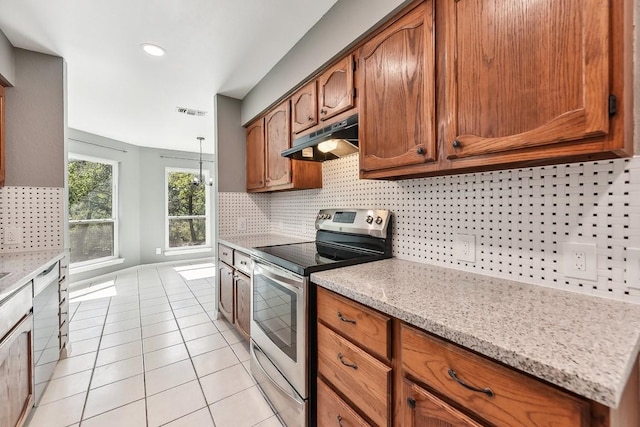 kitchen featuring decorative backsplash, light tile patterned floors, stainless steel appliances, and light stone counters