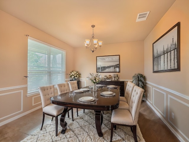 dining area with hardwood / wood-style flooring and a notable chandelier