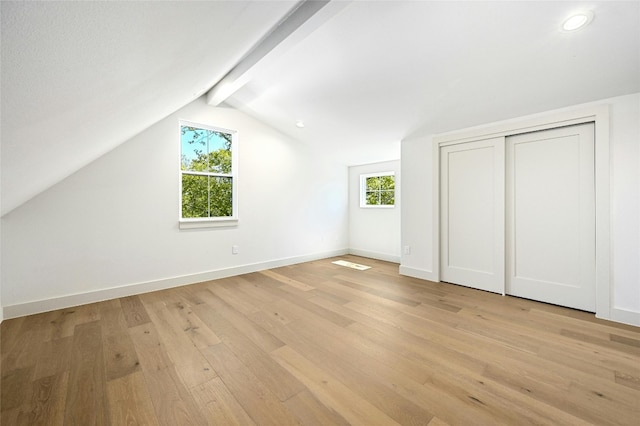 additional living space featuring vaulted ceiling with beams and light hardwood / wood-style floors