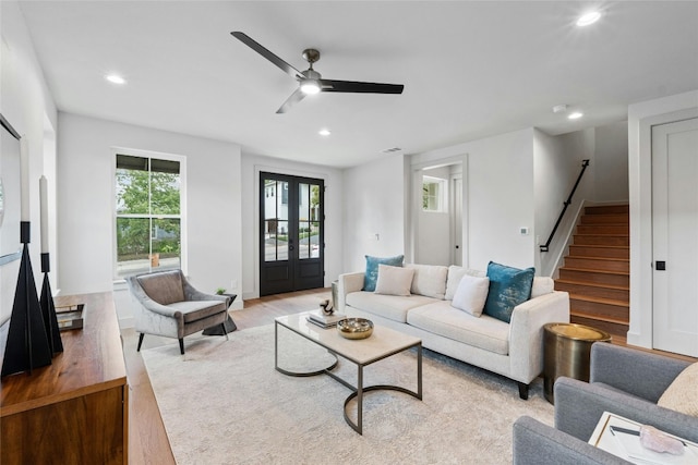 living room with light wood-type flooring, ceiling fan, and french doors