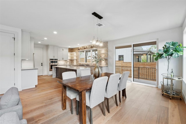 dining room with light wood-type flooring and sink