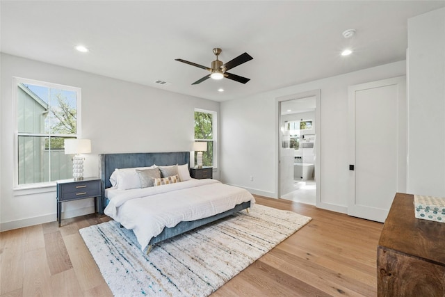 bedroom featuring light hardwood / wood-style floors, ensuite bath, and ceiling fan