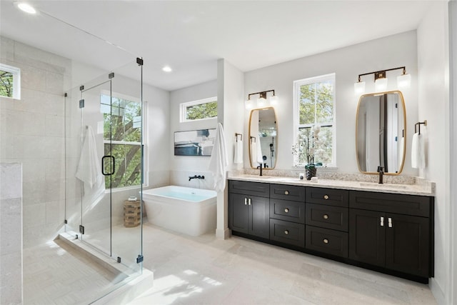 bathroom with plenty of natural light, vanity, and separate shower and tub