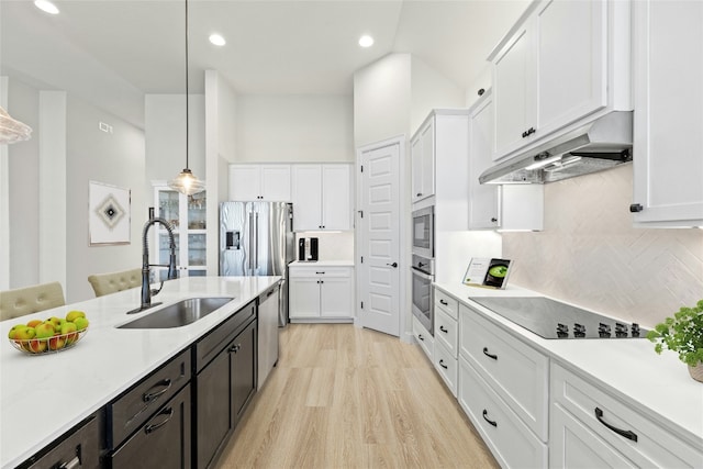 kitchen featuring white cabinets, appliances with stainless steel finishes, decorative light fixtures, and sink