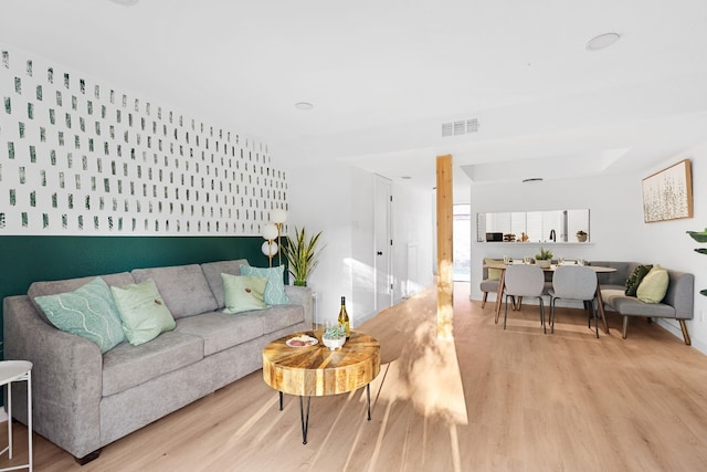 living room with light wood-type flooring and a skylight