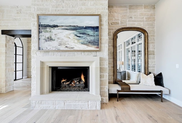 living area with wood-type flooring and a large fireplace