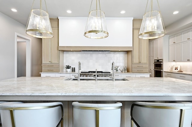 kitchen with a spacious island, double oven, and decorative light fixtures