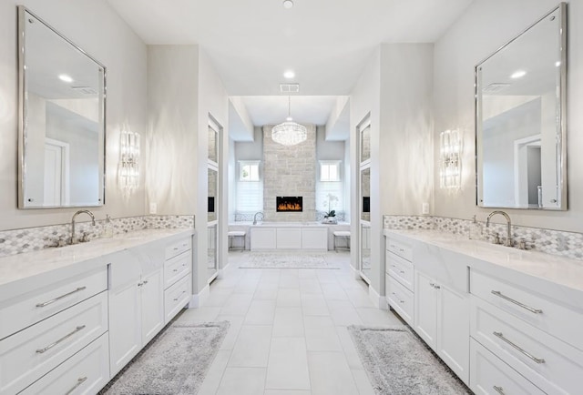 bathroom featuring vanity, a large fireplace, and a tub to relax in