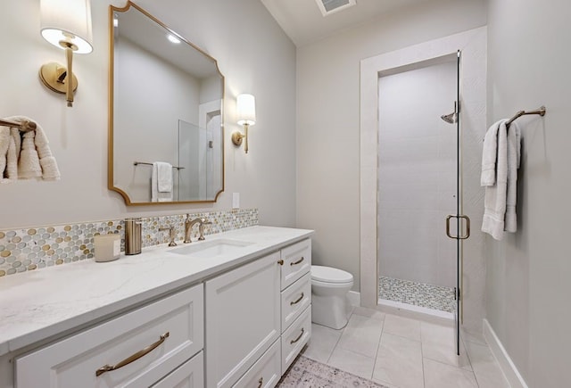 bathroom with backsplash, vanity, tile patterned floors, toilet, and walk in shower