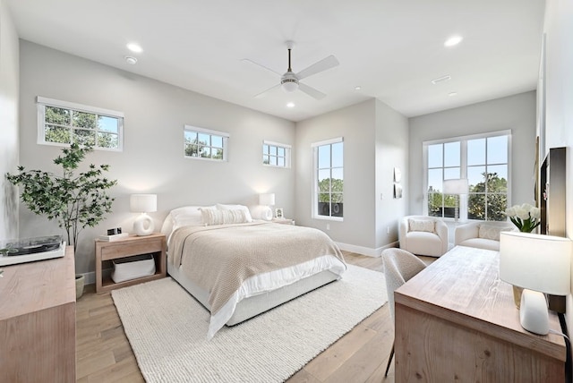 bedroom with multiple windows, ceiling fan, and light wood-type flooring