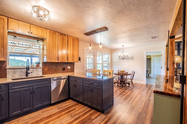 kitchen featuring a wealth of natural light, hardwood / wood-style flooring, sink, and stainless steel dishwasher