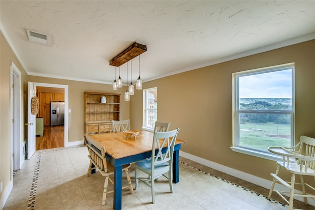 dining space with crown molding and light tile patterned floors