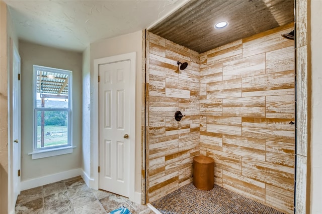 bathroom featuring a shower and wooden walls