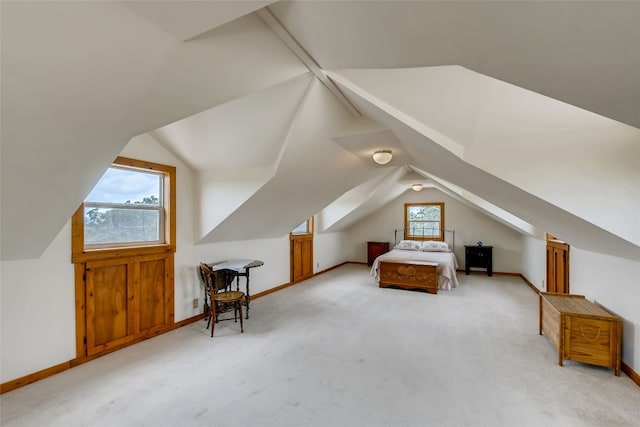 unfurnished bedroom featuring light carpet, lofted ceiling, and multiple windows