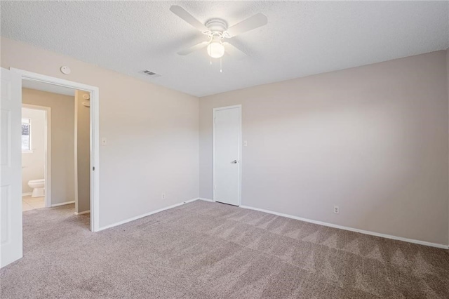 carpeted empty room featuring ceiling fan and a textured ceiling