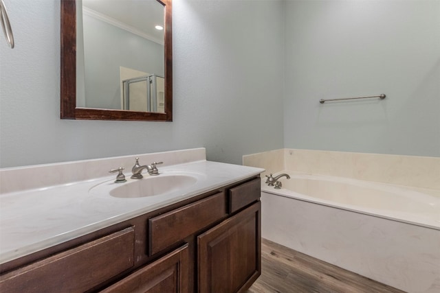 bathroom featuring wood-type flooring, shower with separate bathtub, vanity, and crown molding