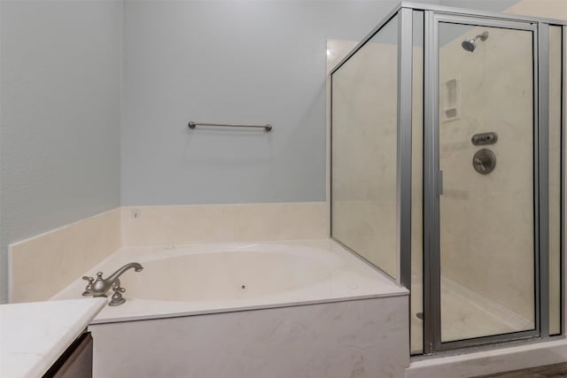 full bath with a stall shower, vanity, and a garden tub