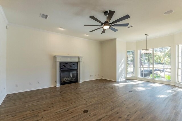 unfurnished living room with ornamental molding, ceiling fan with notable chandelier, dark hardwood / wood-style flooring, and a tile fireplace