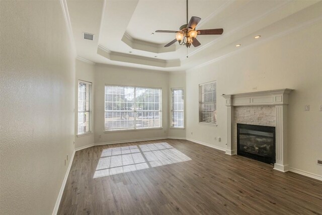 unfurnished living room with ornamental molding, ceiling fan, a fireplace, and dark wood-type flooring