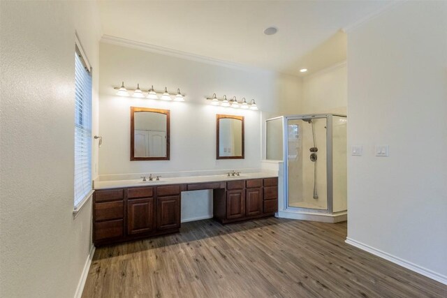 bathroom with hardwood / wood-style flooring, vanity, ornamental molding, and a shower with shower door