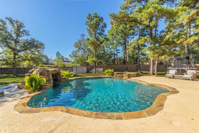 view of pool featuring a storage shed, a patio, a trampoline, and a fenced backyard