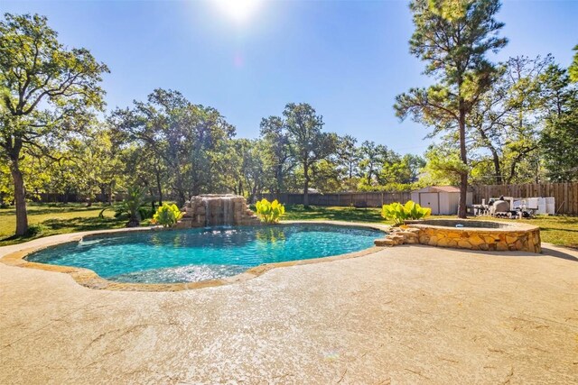 view of swimming pool with a storage shed and a patio area