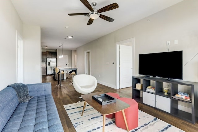 living room featuring ceiling fan and dark hardwood / wood-style floors