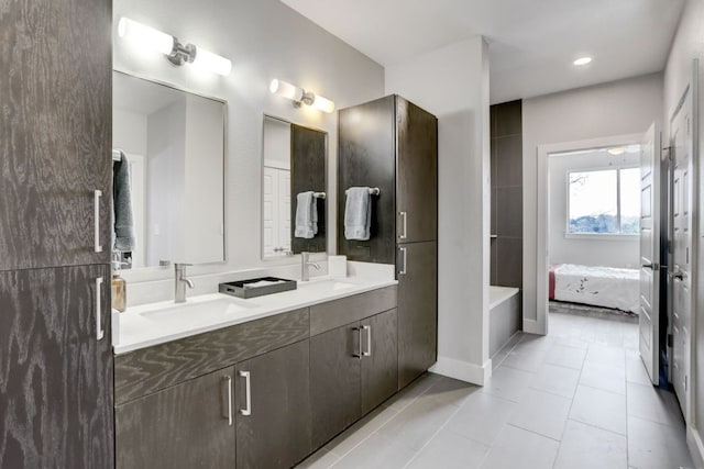 full bath with a sink, double vanity, and tile patterned floors