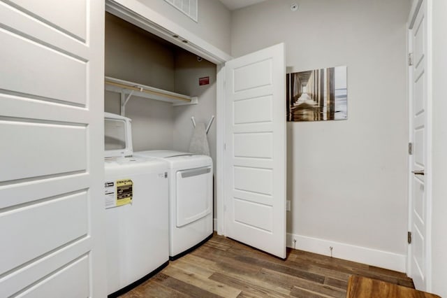 washroom with washer and clothes dryer and dark wood-type flooring