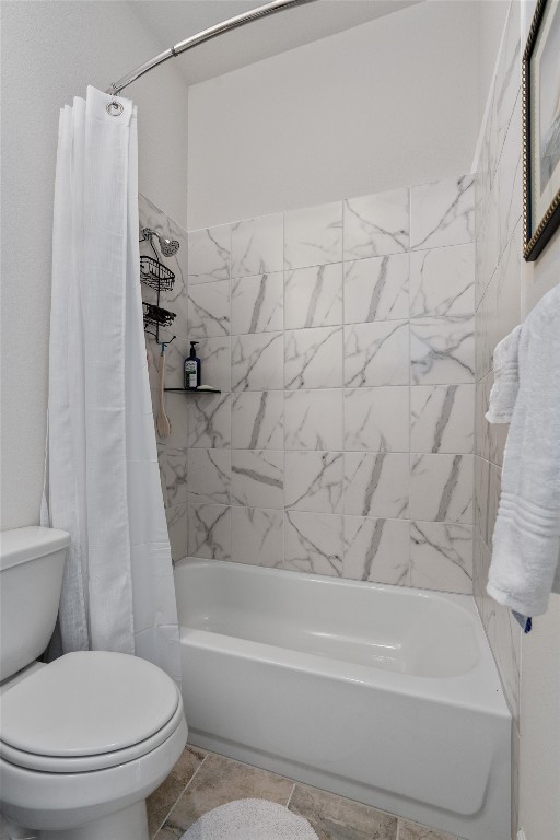 bathroom featuring tile patterned flooring, toilet, and shower / tub combo